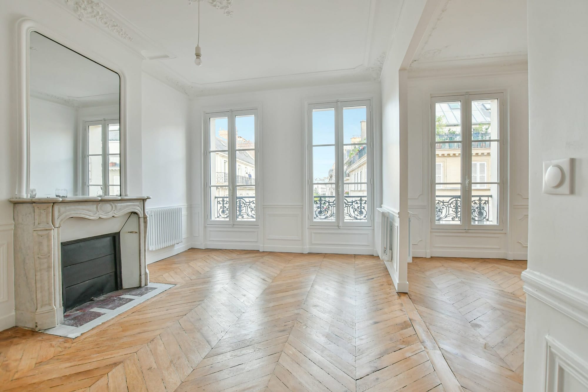 séjour avec 3 fenêtres d'un appartement à Paris 8