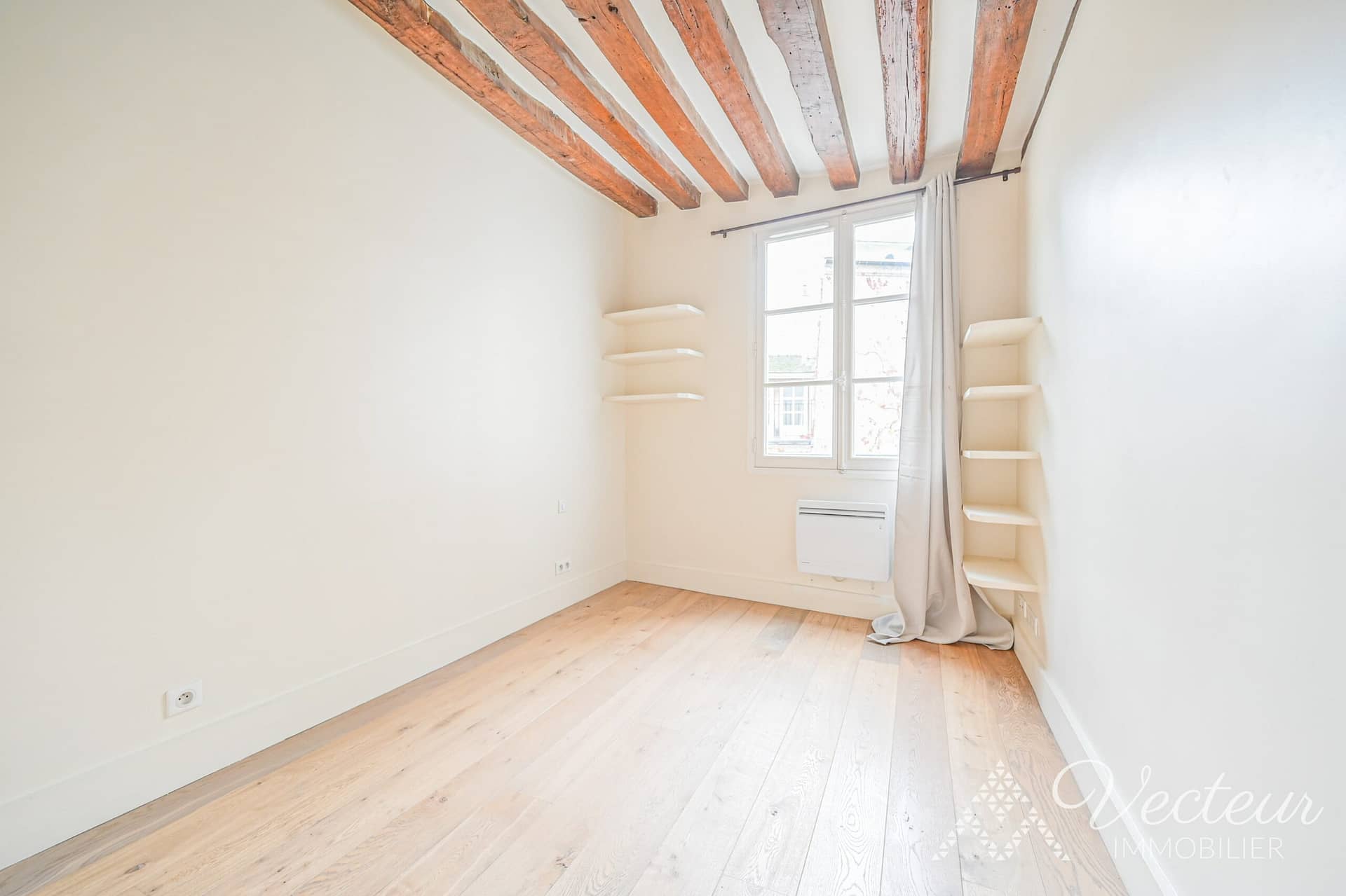 Chambre avec parquet et fenêtre dans un appartement à Paris 5