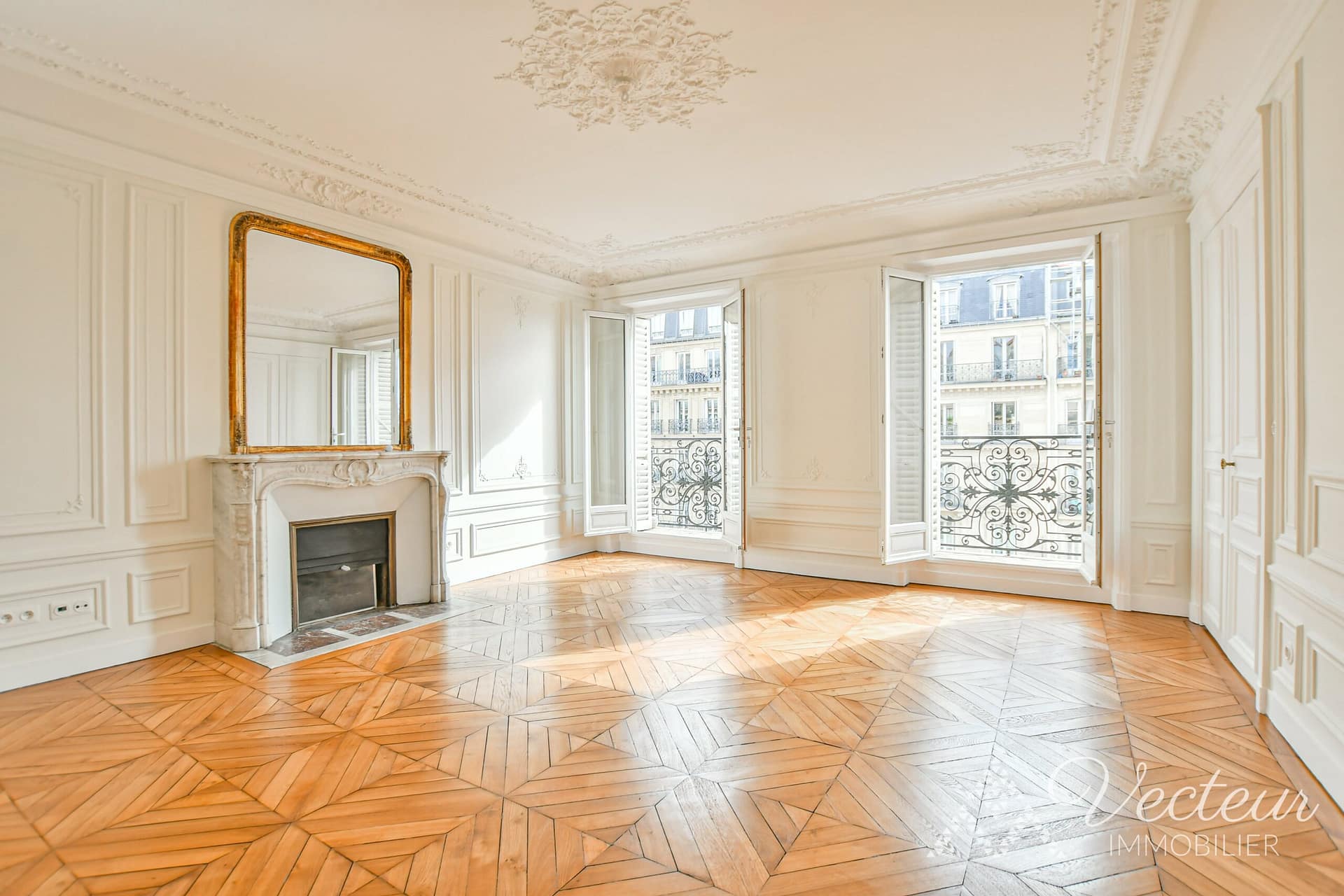 Séjour avec cheminée et 2 fenêtres d'un appartement à Paris 5
