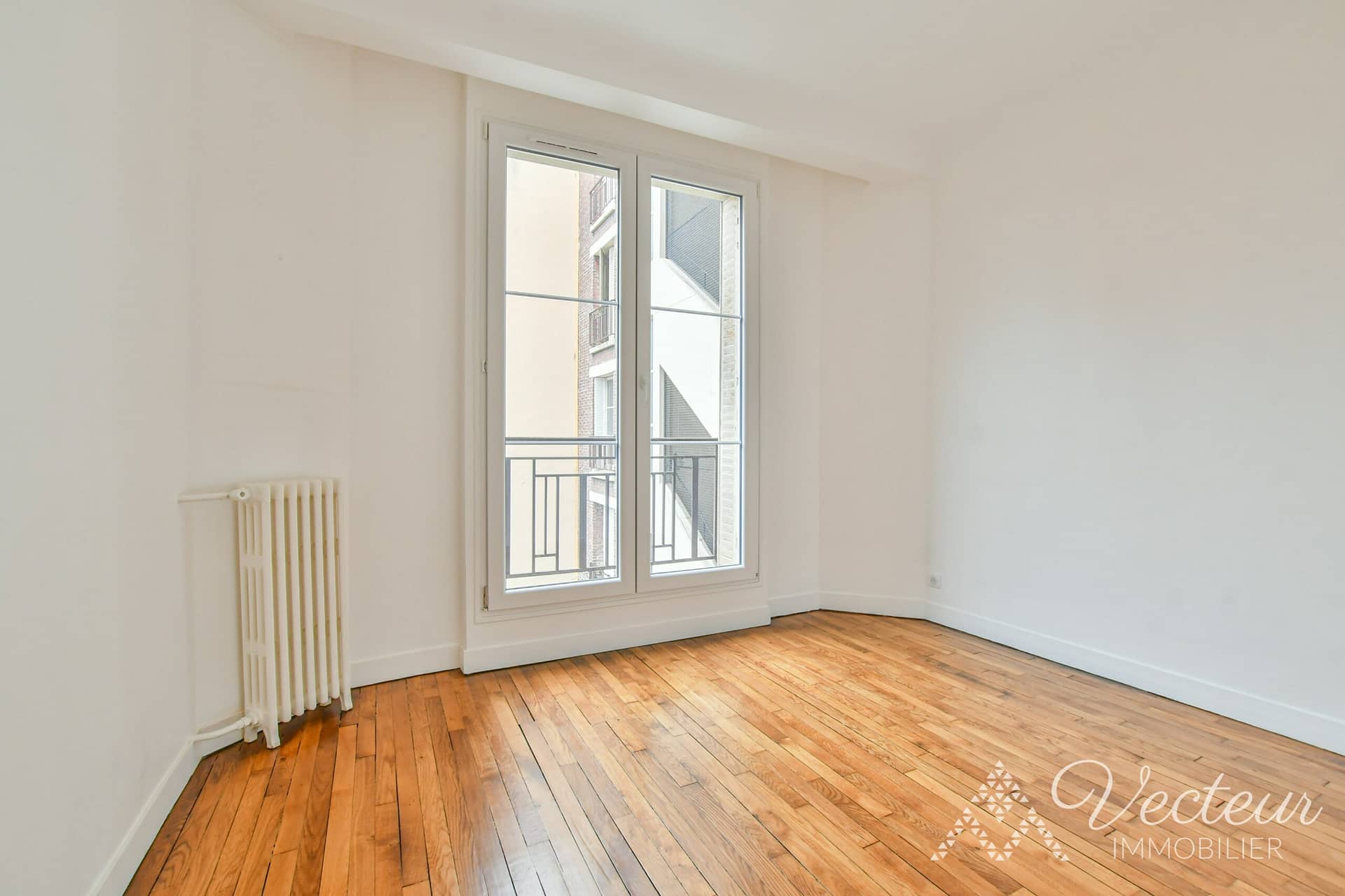 Chambre avec parquet et fenêtre d'un appartement à Paris 15
